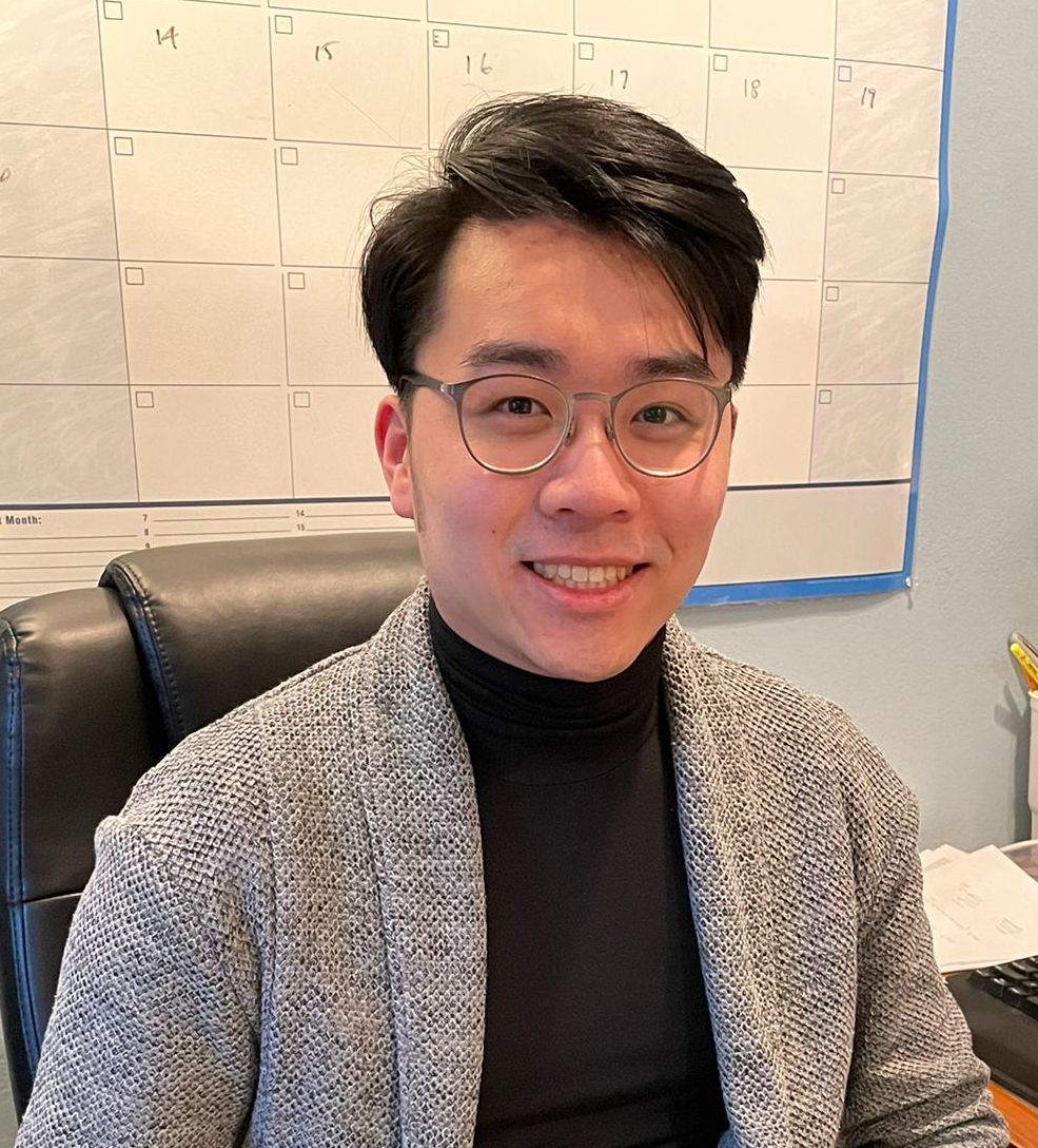 Person with short hair and glasses